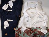 Trois paires de chemises et de pantalons pour homme sont disposées sur une table