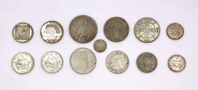a group of silver coins sitting on top of a white surface