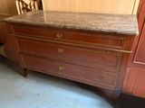 a dresser with a marble top in the corner of a room