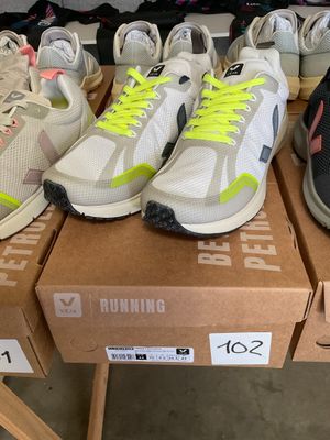 several pairs of running shoes sitting on top of boxes on a table