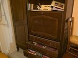 une armoire en bois sur laquelle sont posés des livres, dans un coin de la pièce