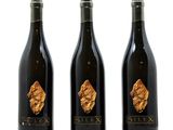 three bottles of wine with a gold leaf on the label