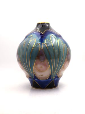 a blue and gold vase sitting on a white surface