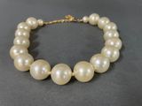 a close up of a pearl necklace on a black surface