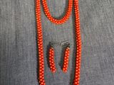 un ensemble composé d'un collier et de boucles d'oreilles en perles de corail
