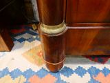 a tall wooden table with a brass plate on top