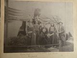 an old black and white photo of a group of people standing in front of a tent
