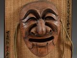 an image of a wooden mask hanging on a wall