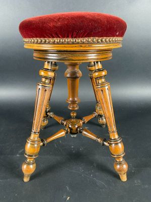 Un tabouret de piano en bois sculpté réglable et recouvert d…