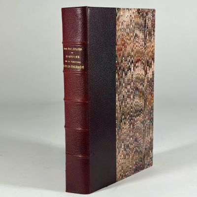 an old book sitting on top of a table next to a white wall