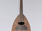 a wooden instrument hanging from a string on a wall