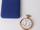 a small gold pocket watch and a blue box