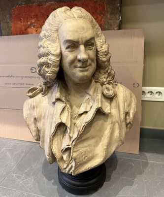 le buste d'un homme aux cheveux longs est posé sur une table
