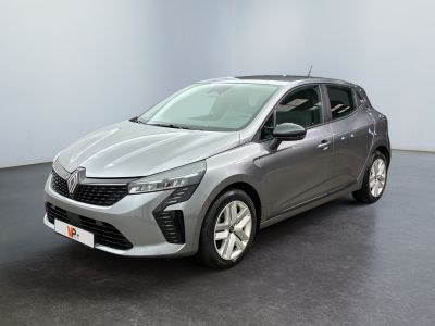 Une voiture argentée est garée dans une pièce au sol noir.
