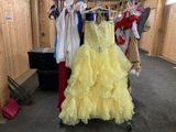 a yellow dress hanging on a rack in a room