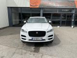 a white jaguar car parked in front of a building