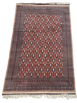 an antique persian rug with geometric design and fringe fringes