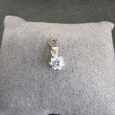 un gros plan sur un coussin sur lequel est posé un pendentif en forme de diamant