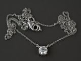 un collier en argent orné d'un diamant, posé sur un fond noir
