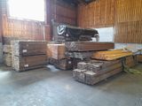 a large pile of wood in a building with a lot of windows