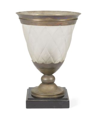 un vase ancien en argent et en verre posé sur un socle en bois