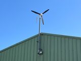 une éolienne au sommet d'un immeuble, avec un ciel bleu en arrière-plan