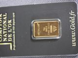 the gold bar is sitting on top of the card on the table