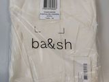 La chemise blanche est emballée dans du plastique et porte le logo « bar and sh ».