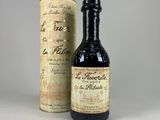 an old bottle of wine sitting next to a cardboard box