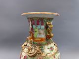 un vase avec un tableau posé sur une table