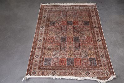 un tapis persan ancien aux motifs rouges et bleus sur un fond gris