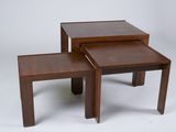 two small tables with one sitting on top of it and one sitting on the ground
