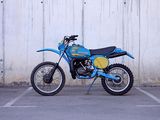 a blue and yellow dirt bike parked in a parking lot