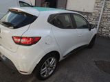 the rear end of a white car parked in front of a building