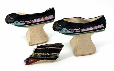 three pairs of shoes that are sitting on a wooden stand