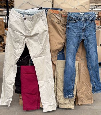 Plusieurs paires de jeans sont empilées les unes sur les autres dans un entrepôt