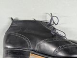 pair of black leather shoes with laces on them on a white surface