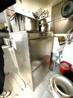 un homme debout dans une cuisine, un faitout à la main