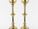 a pair of brass candlesticks with a crown on the top
