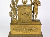 une horloge en or surmontée d'une statue