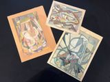 three paintings of different shapes and sizes on a black surface