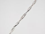 a close up of a silver bracelet on a white surface