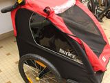 a red and black stroller with a red cover on it