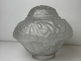 an old glass jar with a lid sitting on a white surface