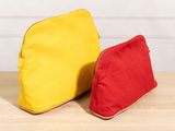 two bags sitting on top of a wooden table next to each other