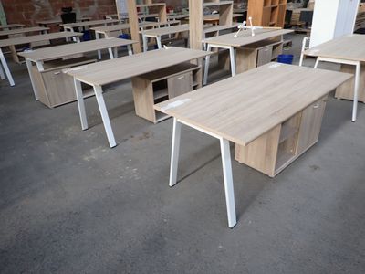 many desks and chairs in a room with a brick wall