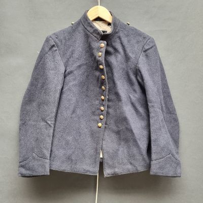 une veste bleue suspendue à un cintre accroché au mur
