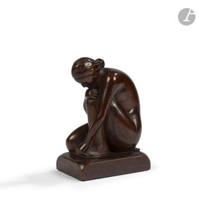 sculpture of a woman kneeling on a wooden base