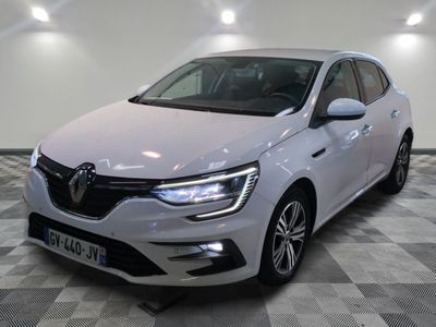 la voiture blanche est garée sur un sol en damier dans le garage
