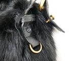 a black furry bag with a gold ring on it